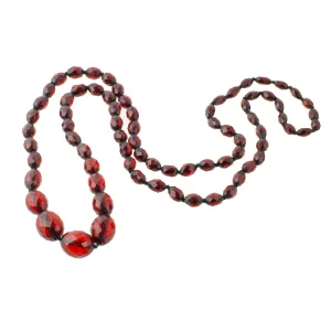 Art Deco long strand of knotted and graduated faceted oval cherry amber Bakelite beads. nlbk789